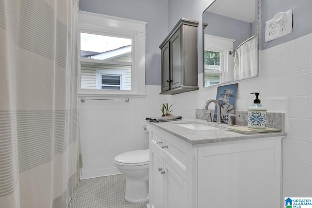 1138 14th Ave S, Birmingham, AL 35205 - bathroom featuring tile walls, toilet, vanity, a wainscoted wall, and tile patterned floors