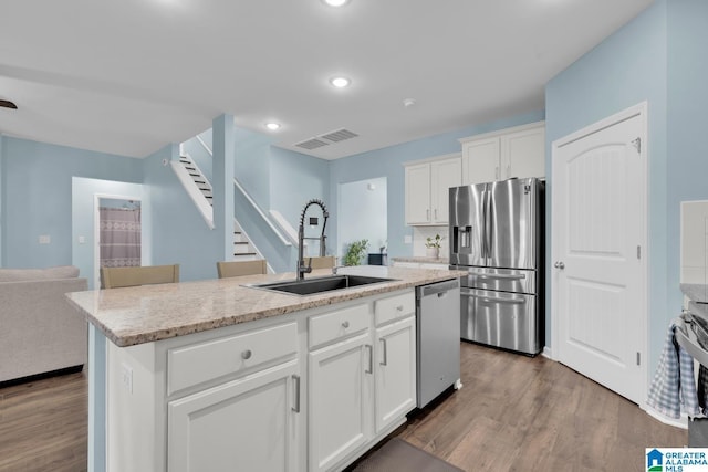 1009 Canvasback Way, Alabaster, AL 35007 - kitchen with stainless steel appliances, wood finished floors, a kitchen island with sink, white cabinets, and recessed lighting