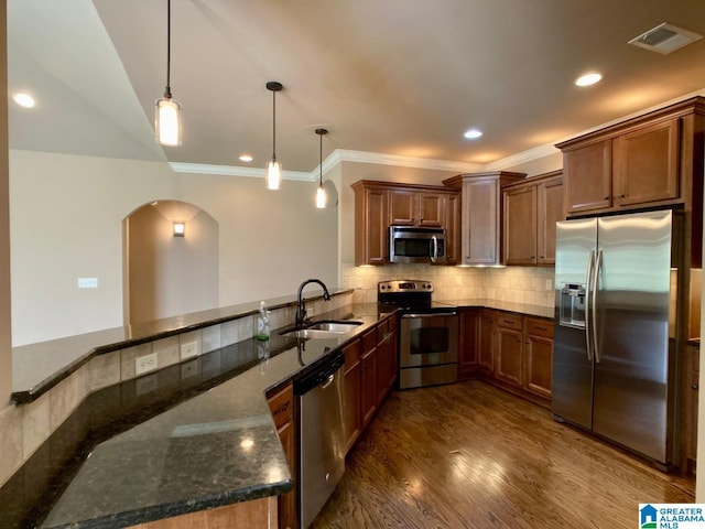 168 Willow View Ln, Westover, AL 35186 - kitchen with appliances with stainless steel finishes, arched walkways, ornamental molding, dark stone countertops, and hanging light fixtures