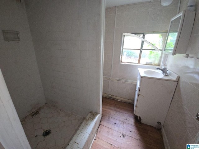 1414 27th St, Birmingham, AL 35218 - full bath featuring vanity, wood finished floors, a shower stall, and tile walls