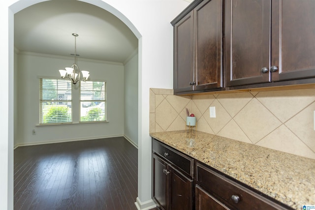 319 Glen Cross Way, Trussville, AL 35173 - kitchen featuring light stone counters, dark brown cabinets, crown molding, tasteful backsplash, and pendant lighting