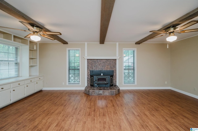 840 Black Acres Rd, Cropwell, AL 35054 - unfurnished living room with a ceiling fan, a wood stove, beamed ceiling, and light wood-type flooring