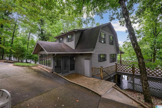 840 Black Acres Rd, Cropwell, AL 35054 - view of front of home with a sunroom, roof with shingles, concrete driveway, a gambrel roof, and a deck