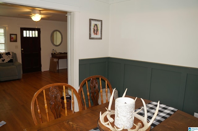 702 4th St SW, Childersburg, AL 35044 - dining area with a decorative wall, ceiling fan, wood finished floors, and wainscoting