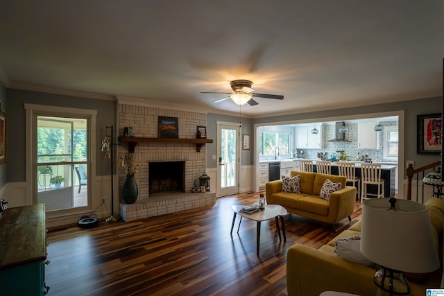 7835 Windsong Dr, Trussville, AL 35173 - living room with a fireplace, a ceiling fan, wood finished floors, ornamental molding, and wainscoting