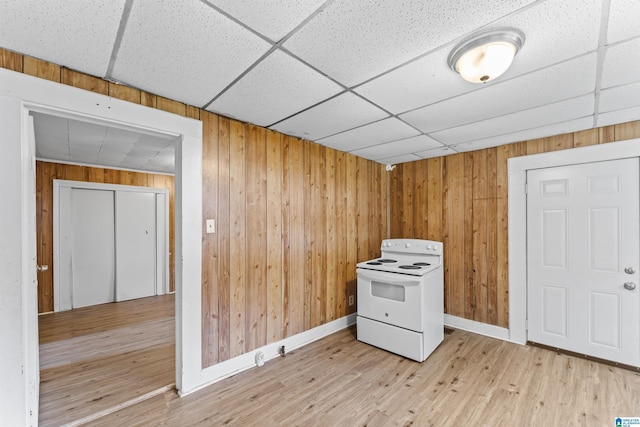 606 W Pine St, Sylacauga, AL 35150 - kitchen featuring white electric range, a drop ceiling, light wood finished floors, and wood walls