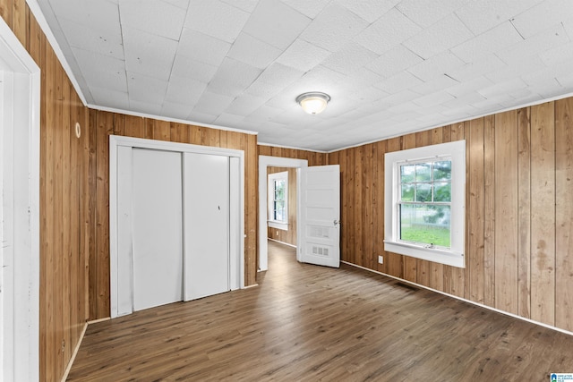 606 W Pine St, Sylacauga, AL 35150 - unfurnished bedroom featuring wood finished floors, wood walls, and a closet