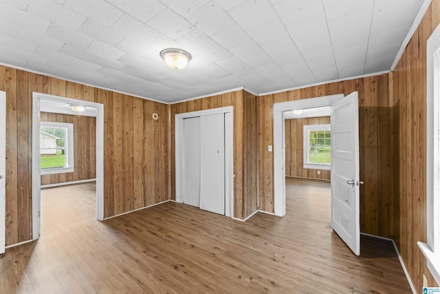 606 W Pine St, Sylacauga, AL 35150 - unfurnished bedroom featuring multiple windows, wood finished floors, a closet, and wood walls