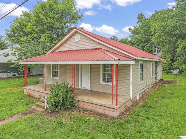 606 W Pine St, Sylacauga, AL 35150 - view of front of home with a porch, a metal roof, and a front yard