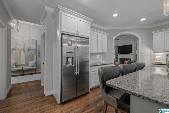 2000 Regency Way, Birmingham, AL 35242 - kitchen with stainless steel fridge with ice dispenser, ornamental molding, arched walkways, a fireplace, and dark wood-type flooring