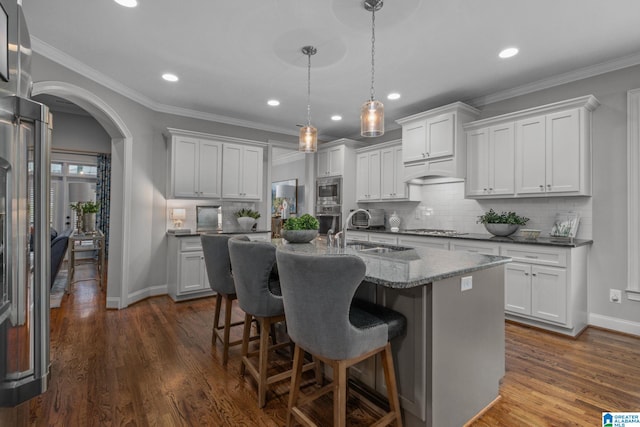 2000 Regency Way, Birmingham, AL 35242 - kitchen featuring stainless steel appliances, arched walkways, recessed lighting, a kitchen bar, and a center island with sink