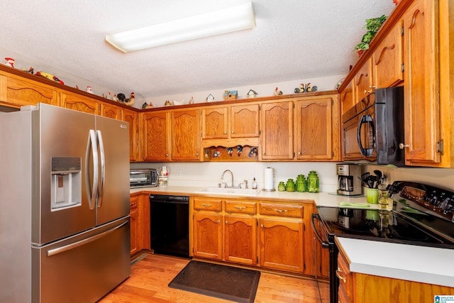 20571 Faynell Cir, Woodstock, AL 35188 - kitchen with black appliances, brown cabinetry, light countertops, light wood-type flooring, and a textured ceiling