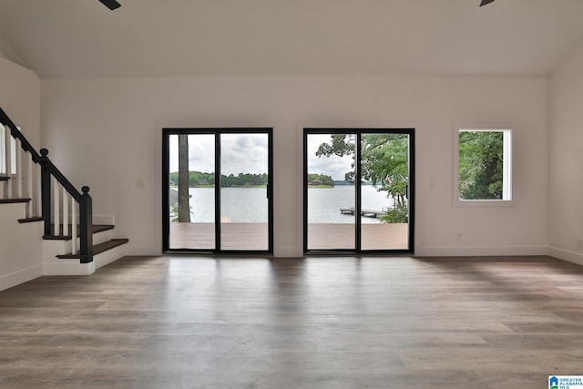 442 Lakeview Cir, Alpine, AL 35014 - spare room with wood finished floors, stairway, a ceiling fan, and a water view