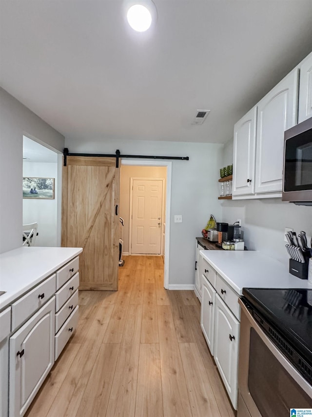 489 Bailey Loop Rd, Gardendale, AL 35071 - kitchen with appliances with stainless steel finishes, white cabinetry, a barn door, and light countertops
