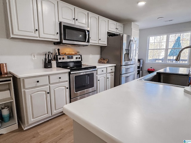 489 Bailey Loop Rd, Gardendale, AL 35071 - kitchen with appliances with stainless steel finishes, light wood-type flooring, white cabinets, and light countertops