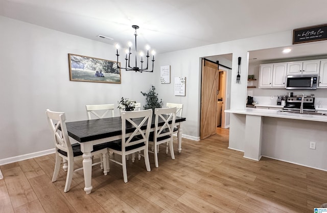 489 Bailey Loop Rd, Gardendale, AL 35071 - dining room with light wood-style floors, a chandelier, and a barn door