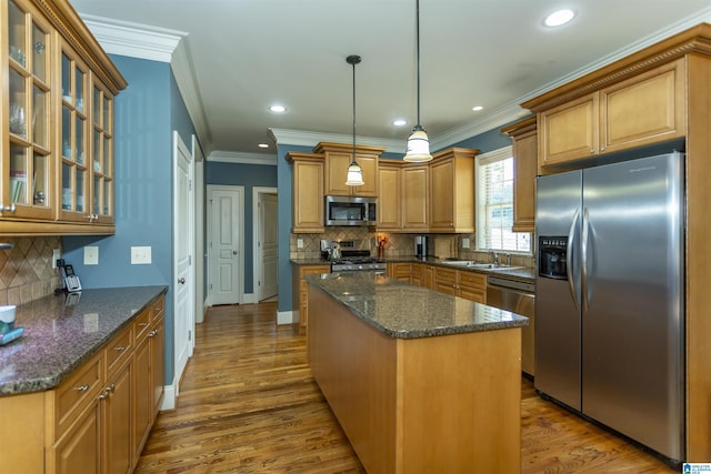 5668 Carrington Lake Pkwy, Trussville, AL 35173 - kitchen with stainless steel appliances, a center island, backsplash, crown molding, and wood finished floors