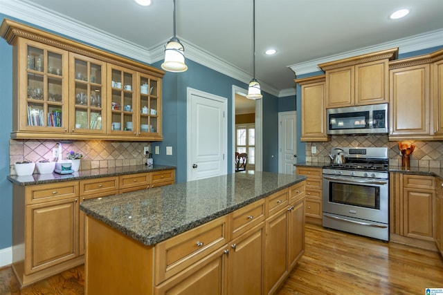 5668 Carrington Lake Pkwy, Trussville, AL 35173 - kitchen featuring appliances with stainless steel finishes, tasteful backsplash, pendant lighting, crown molding, and glass insert cabinets