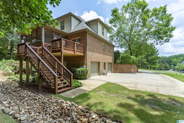 5668 Carrington Lake Pkwy, Trussville, AL 35173 - back of property with a sunroom, brick siding, a garage, stairs, and concrete driveway