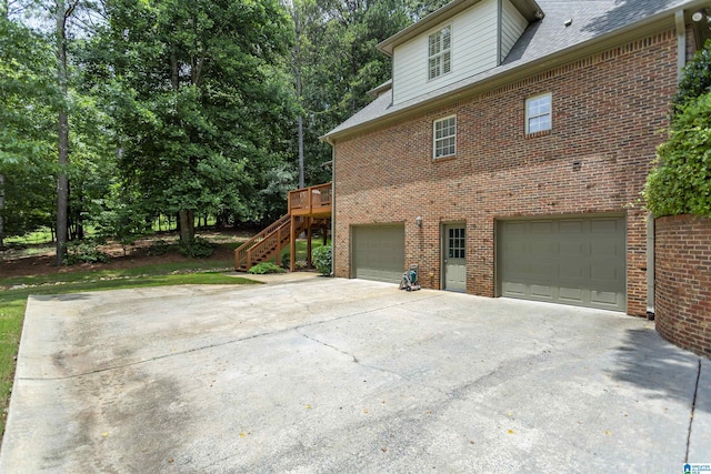 5668 Carrington Lake Pkwy, Trussville, AL 35173 - view of side of home featuring brick siding, stairs, an attached garage, driveway, and a deck