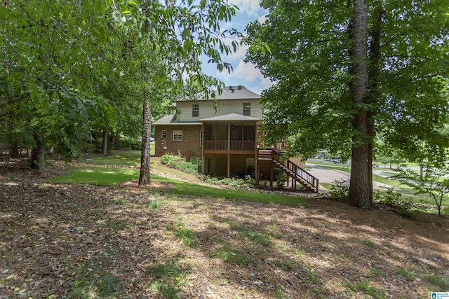 5668 Carrington Lake Pkwy, Trussville, AL 35173 - back of house featuring a sunroom, stairway, brick siding, and a lawn