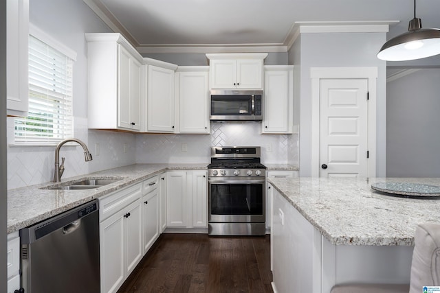 7593 Paine Dr, Trussville, AL 35173 - kitchen featuring stainless steel appliances, ornamental molding, white cabinetry, dark wood-style floors, and light stone countertops
