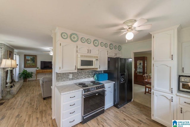 1912 Tall Timbers Dr, Hoover, AL 35226 - kitchen with white microwave, range with electric stovetop, a ceiling fan, black refrigerator with ice dispenser, and white cabinetry