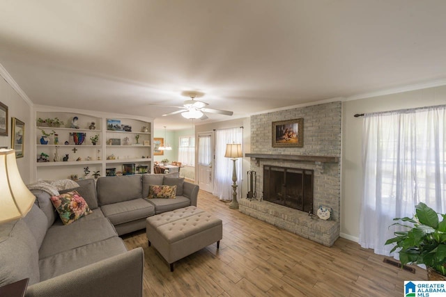 1912 Tall Timbers Dr, Hoover, AL 35226 - living area featuring a fireplace, a ceiling fan, light wood-type flooring, and ornamental molding