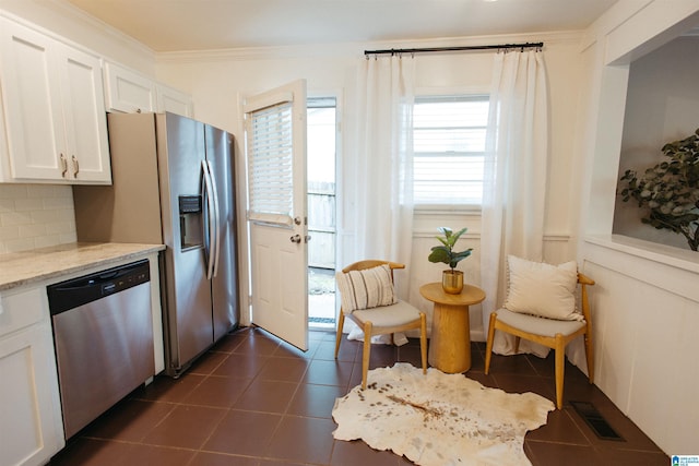 4648 Clairmont Ave S, Birmingham, AL 35222 - kitchen with dishwasher, white cabinets, crown molding, dark tile patterned floors, and light stone countertops