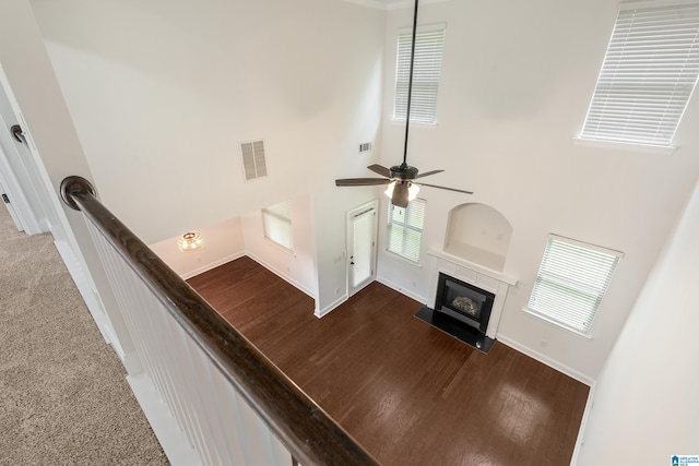 5381 Park Side Cir, Hoover, AL 35244 - unfurnished living room featuring a glass covered fireplace, plenty of natural light, a ceiling fan, a high ceiling, and wood finished floors