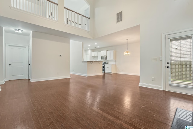 5381 Park Side Cir, Hoover, AL 35244 - unfurnished living room featuring a towering ceiling, dark wood-style flooring, and plenty of natural light