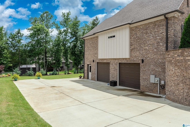 715 W Cassie Dr, Pell City, AL 35128 - view of side of home featuring concrete driveway, an attached garage, roof with shingles, and brick siding