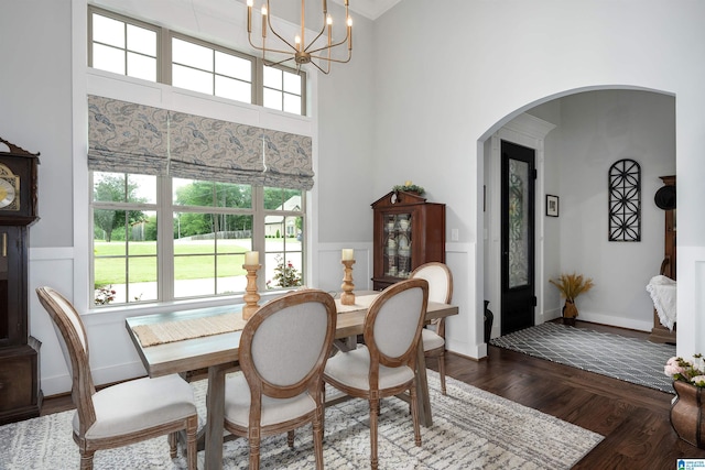 715 W Cassie Dr, Pell City, AL 35128 - dining area featuring dark wood-type flooring, a decorative wall, arched walkways, a chandelier, and wainscoting