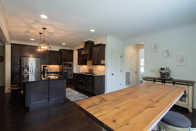 5250 Kate Cv, Trussville, AL 35173 - kitchen featuring appliances with stainless steel finishes, custom range hood, dark countertops, backsplash, and a kitchen bar