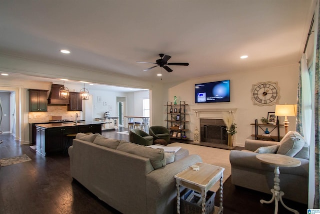 5250 Kate Cv, Trussville, AL 35173 - living area with dark wood-style floors, a ceiling fan, recessed lighting, a fireplace with raised hearth, and crown molding