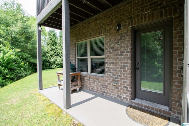 5250 Kate Cv, Trussville, AL 35173 - view of exterior entry featuring brick siding, a yard, a patio area, and a balcony