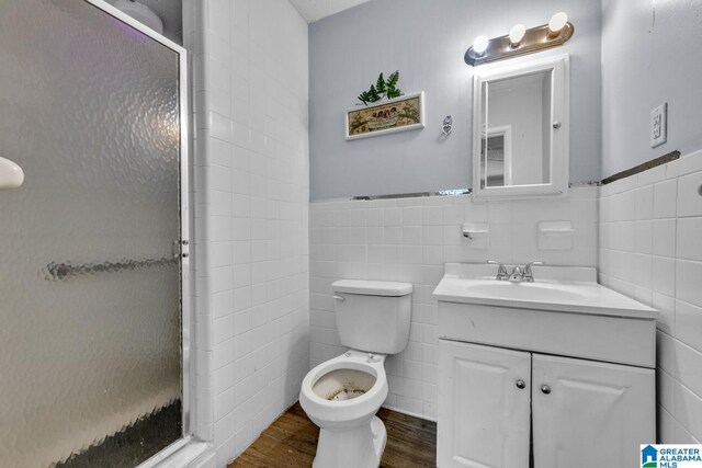 1821 4th St NW, Center Point, AL 35215 - bathroom with vanity, a stall shower, wood finished floors, tile walls, and wainscoting