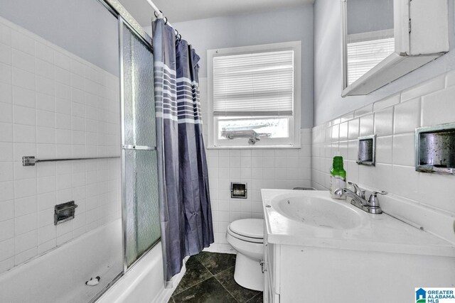 1821 4th St NW, Center Point, AL 35215 - bathroom with bath / shower combo with glass door, vanity, tile patterned floors, and tile walls