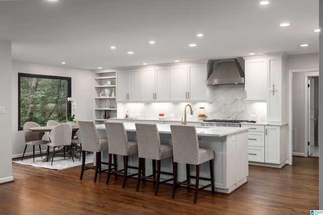 3709 Dover Dr, Mountain Brook, AL 35223 - kitchen with wall chimney exhaust hood, a center island with sink, open shelves, white cabinetry, and recessed lighting