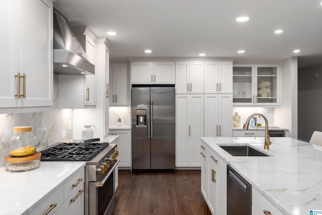 3709 Dover Dr, Mountain Brook, AL 35223 - kitchen featuring stainless steel appliances, wall chimney range hood, decorative backsplash, dark wood-style floors, and white cabinetry