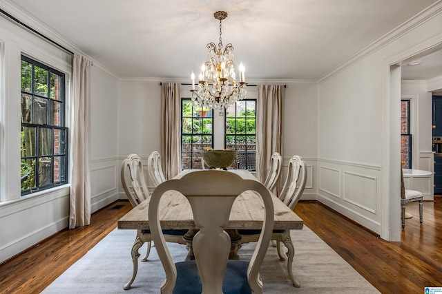 3443 Cliff Rd S, Birmingham, AL 35205 - dining room featuring a chandelier, healthy amount of natural light, dark wood-style flooring, a decorative wall, and ornamental molding