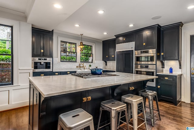 3443 Cliff Rd S, Birmingham, AL 35205 - kitchen featuring stainless steel appliances, crown molding, dark wood-style floors, a kitchen breakfast bar, and light stone countertops