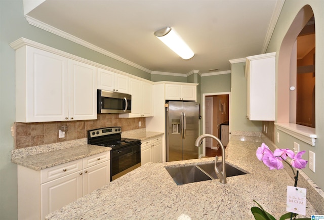 401 Waterford Highlands Way, Calera, AL 35040 - kitchen featuring stainless steel appliances, light stone countertops, crown molding, arched walkways, and tasteful backsplash