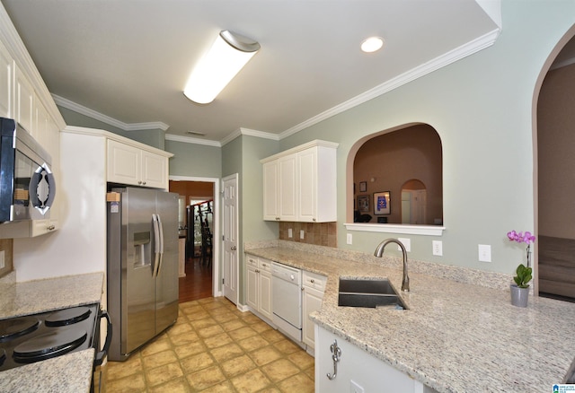 401 Waterford Highlands Way, Calera, AL 35040 - kitchen with appliances with stainless steel finishes, arched walkways, ornamental molding, white cabinets, and light stone counters