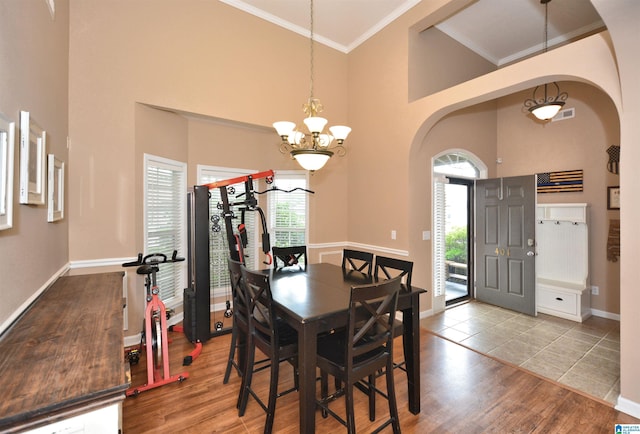 401 Waterford Highlands Way, Calera, AL 35040 - dining area featuring arched walkways, a high ceiling, a chandelier, wood finished floors, and crown molding