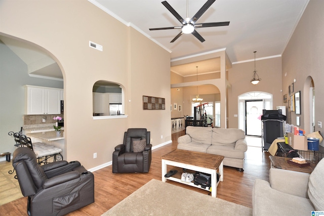 401 Waterford Highlands Way, Calera, AL 35040 - living room with arched walkways, a ceiling fan, light wood-style floors, ornamental molding, and a chandelier