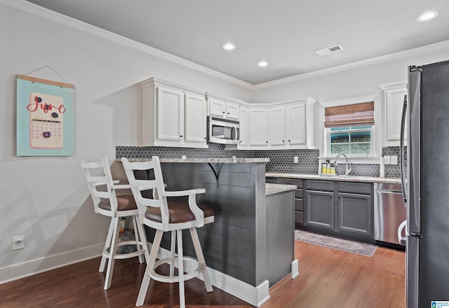1221 Grants Way, Irondale, AL 35210 - kitchen featuring stainless steel appliances, light stone counters, white cabinetry, wood finished floors, and recessed lighting