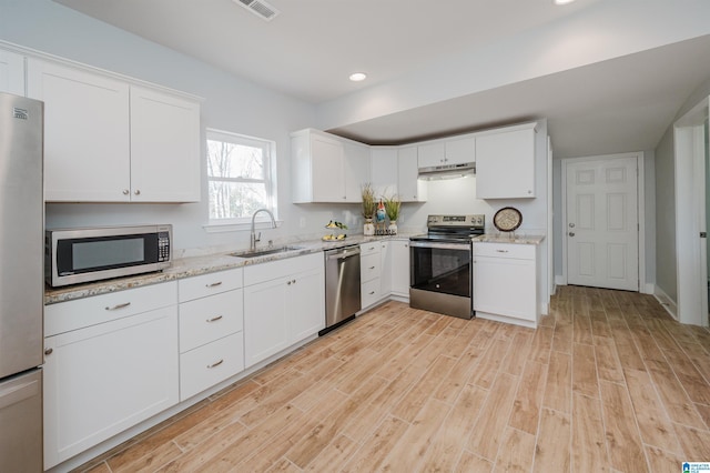 1330 14th Ave N, Bessemer, AL 35020 - kitchen with stainless steel appliances, under cabinet range hood, light wood-style floors, light stone countertops, and recessed lighting