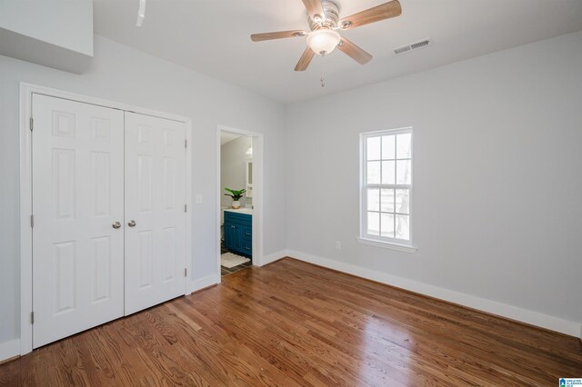 1330 14th Ave N, Bessemer, AL 35020 - unfurnished bedroom with a closet, wood finished floors, ensuite bathroom, and ceiling fan