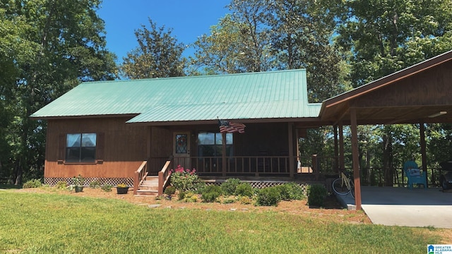 26718 Bridge Ln, Andalusia, AL 36421 - view of front of house with covered porch, a front lawn, a metal roof, and a carport
